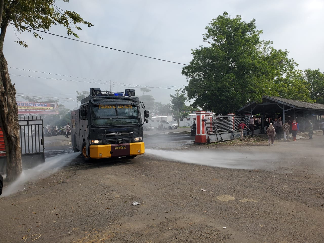 Gunakan Watercanon,Polres Blitar Kota Semprotkan Disinfektan di Pasar Dimoro